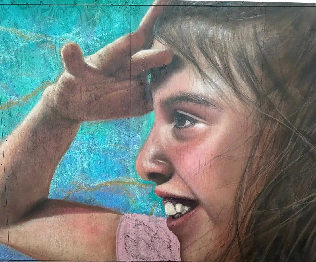 Retrato hiperrealista de mujer pintado con spray en fachada exterior